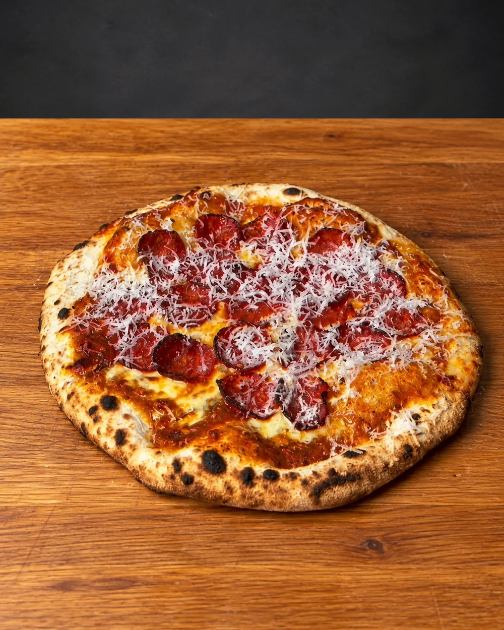 Pepperoni pizza finished with grated parmesan