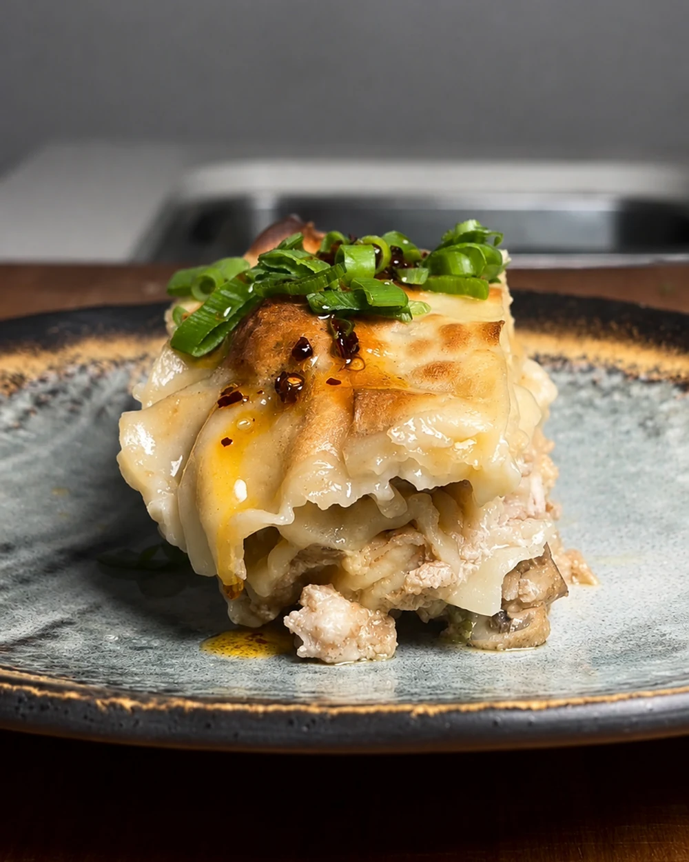 Slice of dumpling lasagne with spring onion and chilli crisp